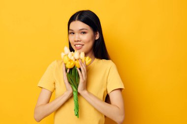 Bir buket sarı çiçekli Asyalı kadın. Romantik stüdyo modeli değiştirilmemiş.