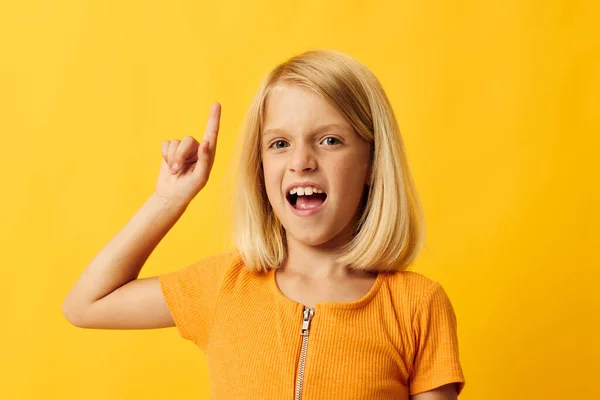 Cheerful little girl hand gesture and fun yellow background — Stock fotografie