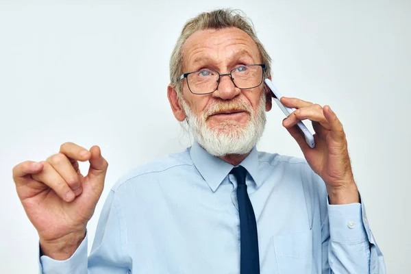 Anciano en camisa con corbata con tecnología de teléfono fondo claro —  Fotos de Stock
