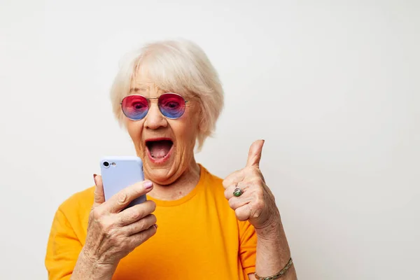 일시적 인 티셔츠에 선글라스를 끼고 있는 은퇴 한 할머니의 사진, 전화를 걸어 친밀 한 감정에 대해 이야기하는 모습 — 스톡 사진