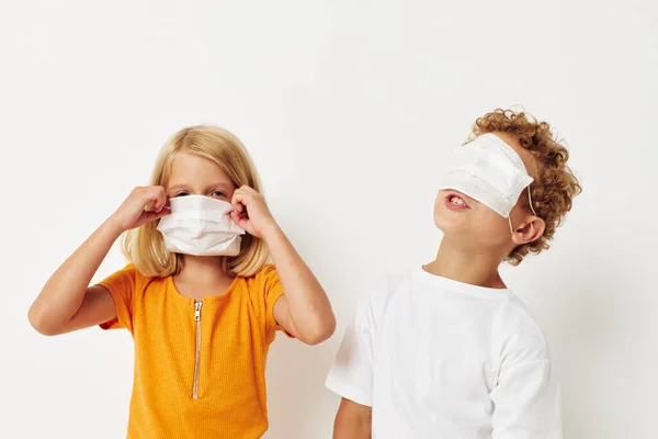 Nette Vorschulkinder in medizinischer Maske Schutz posiert Fratze isolierten Hintergrund unverändert — Stockfoto