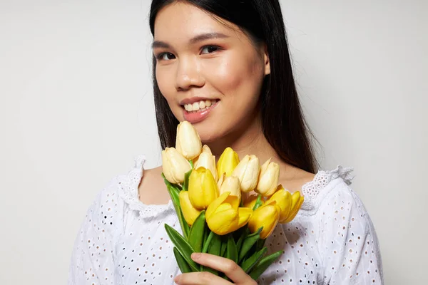 Hezká brunetka s kyticí květin úsměv close-up životní styl beze změny — Stock fotografie