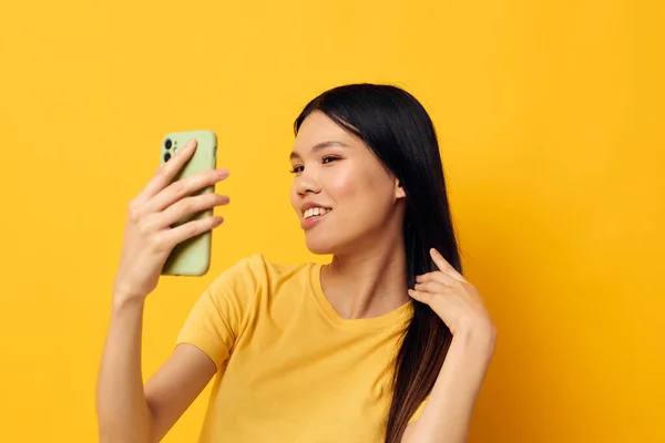 Mujer con un teléfono en sus manos hace un modelo de estudio selfie inalterado — Foto de Stock