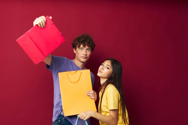 Adolescents en T-shirts colorés avec sacs Shopping fond isolé inchangé — Photo