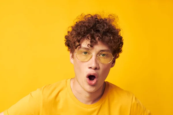 젊은 곱슬머리 청년 스타일의 안경 스튜디오 평범하게 노란 배경을 아무런 변화 없이 입고 — 스톡 사진