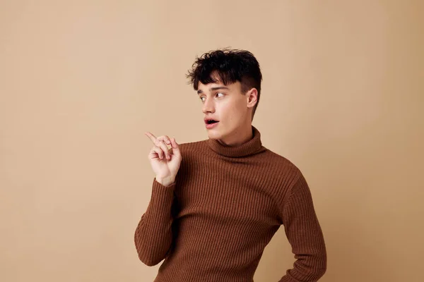 Красивий хлопець позує в коричневому светрі впевненість у собі мода ізольований фон незмінний — стокове фото