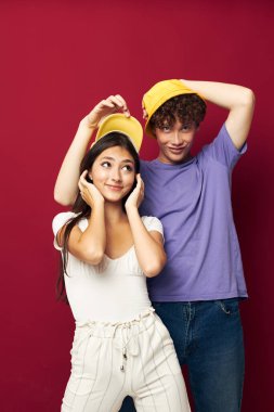 Renkli tişörtler içinde hoş bir adam ve kız şık elbiseler ve izole edilmiş şapkalar.