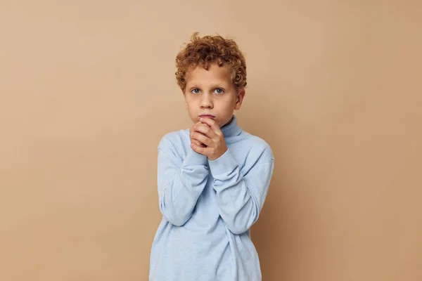 Chico rizado en un suéter azul posando divertida infancia inalterada — Foto de Stock