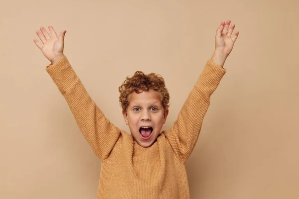 Roztomilý chlapeček v béžovém svetru pózuje zábavné dětství beze změny — Stock fotografie