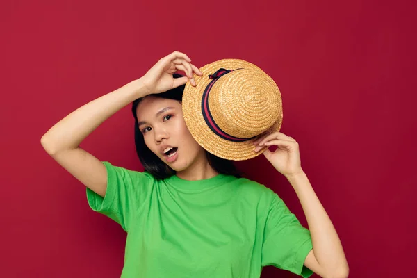Hezká brunetka gesta s rukama s kloboukem v zeleném tričku studio model beze změny — Stock fotografie