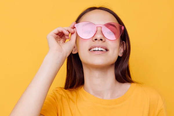 Attraktiv kvinna mode i gul t-shirt denim shorts gul bakgrund — Stockfoto