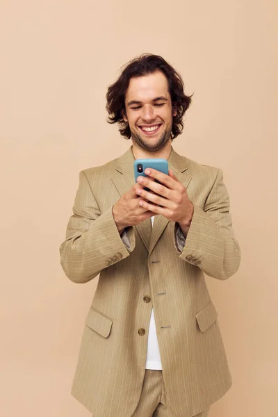 Homem atraente com um telefone na mão bege terno estilo elegante Estilo de vida inalterado — Fotografia de Stock