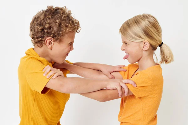 노란 티셔츠를 입고 나란히 서 있는 2 명의 즐거운 아이들은 어린 시절의 감정을 그대로 간직하고 있습니다. — 스톡 사진