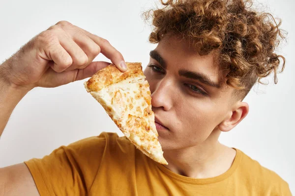 Kinky guy in een geel t-shirt eten pizza Lifestyle ongewijzigd — Stockfoto