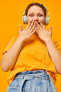 Güzel kız sarı tişörtlü kulaklıklar eğlenceli müzik izole edilmiş arka planlar değiştirilmemiş