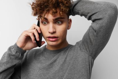 Telefonda konuşan çekici bir adam. Duygularını dışa vuruyor.