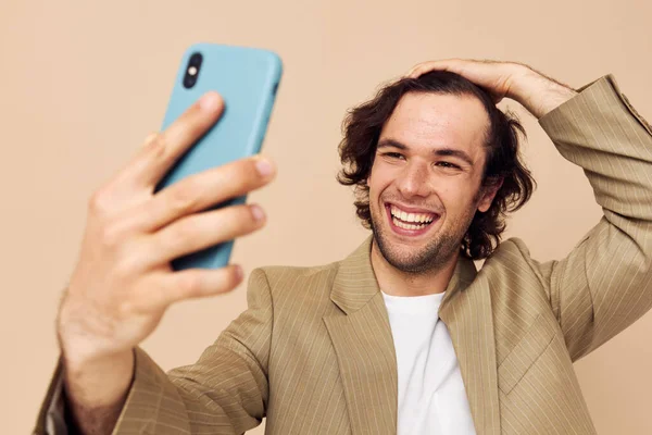 Homem atraente em um terno posando emoções olhando para o telefone isolado fundo — Fotografia de Stock