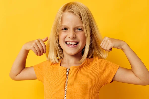 Portret van een klein meisje in een geel t-shirt glimlach poseren studio jeugd levensstijl ongewijzigd — Stockfoto