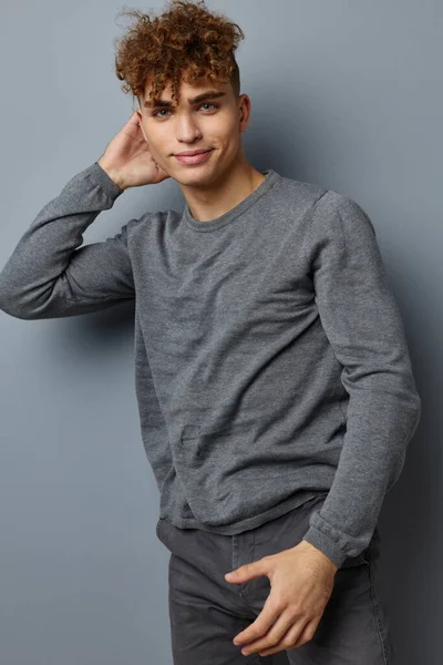 スタイリッシュな男で灰色のトレーナーファッションスタジオグレーの背景 — ストック写真