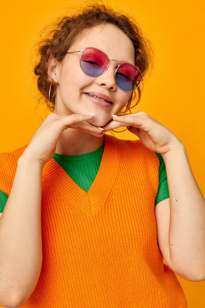 Retrato de uma jovem mulher laranja sweatshirts óculos de sol óculos multicoloridos fornecimento Estilo de vida inalterado — Fotografia de Stock