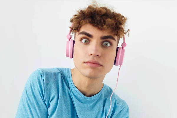 Eccentrico ragazzo in blu t-shirt rosa cuffie moda luce sfondo — Foto Stock