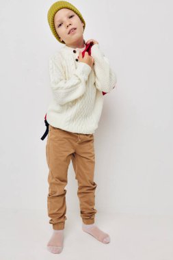 Güzel bir kız okul çantası ve kafasında şapkası var.