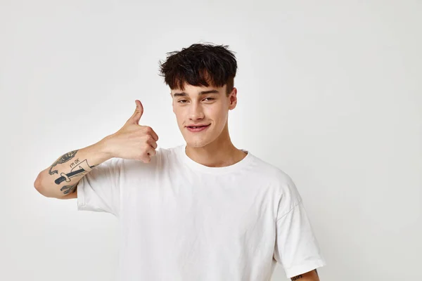 En ung man modern ungdom stil vit t-shirt tatuering på armen Livsstil oförändrad — Stockfoto