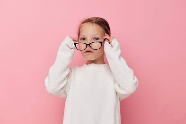 Portrait d'enfant souriant heureux fille dans un pull blanc et des lunettes fond isolé — Photo