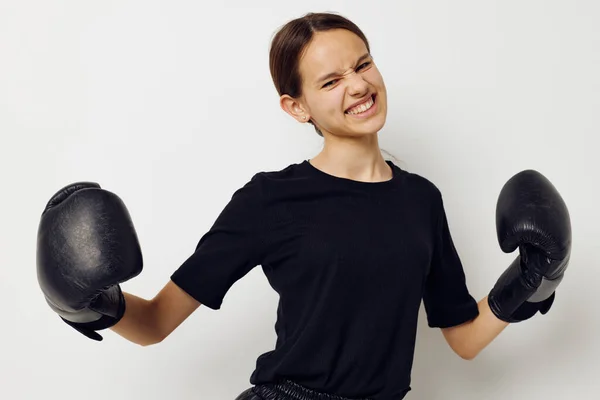 Joven mujer en negro deportes uniforme guantes de boxeo posando estilo de vida inalterado — Foto de Stock