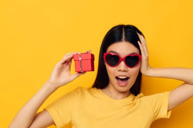 Güzel esmer moda gözlükleri hediye tatil sarı arka plan değiştirilmemiş