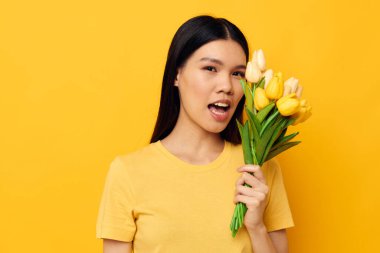 Asyalı güzel bir çiçek buketi. İlkbaharda sarı arka plan pozu veriyor.