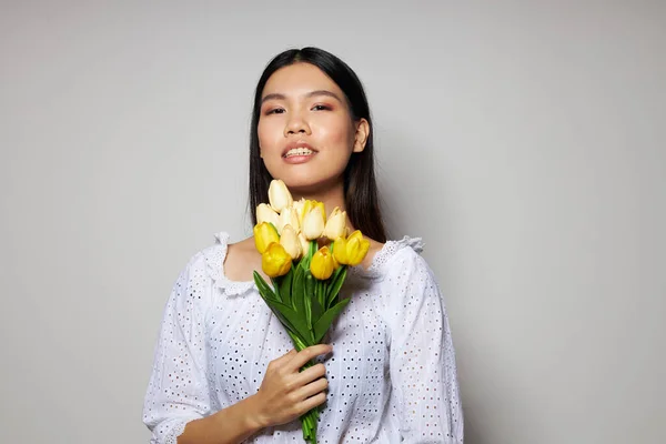 Portrét asijské krásné mladé ženy romantika kytice květin v blízkosti obličeje světlo na pozadí beze změny — Stock fotografie