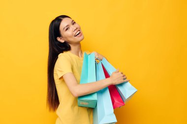 El alışverişinde paketleri olan Asyalı güzel kadın portresi. Değişmemiş yaşam tarzı.
