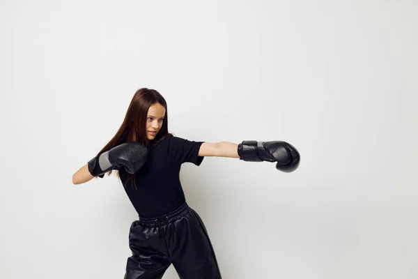Hermosa chica en negro deportes uniforme guantes de boxeo posando entrenamiento de fitness — Foto de Stock