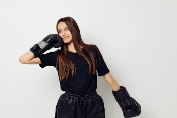 Joven mujer en negro deportes uniforme guantes de boxeo posando estilo de vida inalterado — Foto de Stock