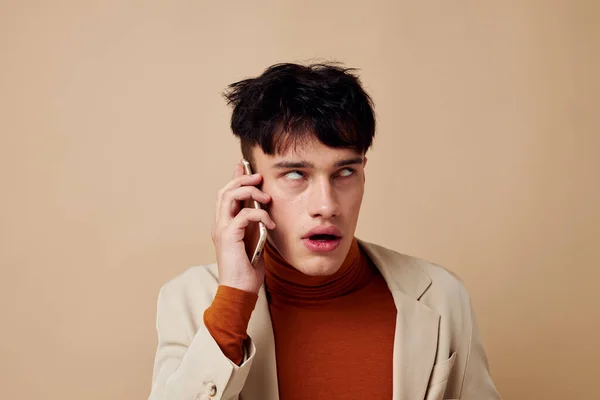 Chico guapo posando con un teléfono en sus manos en una chaqueta de estilo elegante estilo de vida inalterado — Foto de Stock