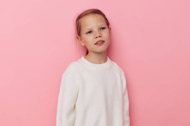 Tatlı kız beyaz süveter çocukluk pozu veriyor.