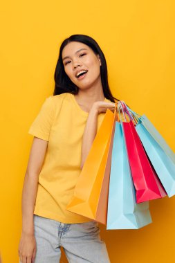 El alışverişinde paketleri olan Asyalı güzel bir genç kadın portresi. Stüdyo modeli değişmemiş.