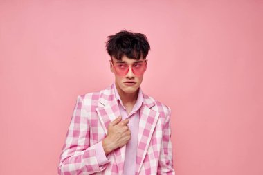 Romantik genç erkek arkadaşın fotoğrafı pembe gözlüklü damalı ceket modayla değiştirilmemiş pembe arka plan pozu.