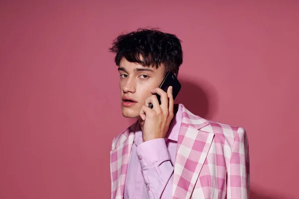 Красивый парень с телефоном в руке розовый пиджак мода элегантный стиль жизни неизменным — стоковое фото
