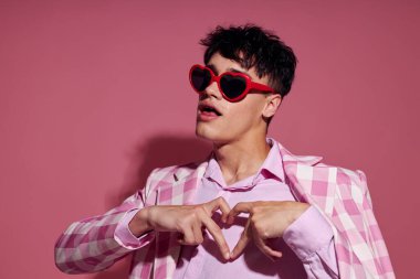 Genç bir adamın portresi ekose ceket modern tarz gözlük pembe arka plan değiştirilmemiş.