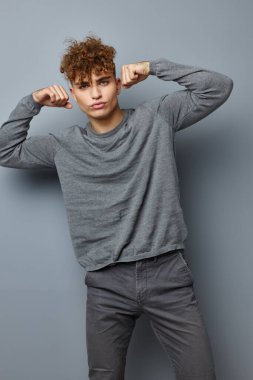 Gri kazaklı yakışıklı adam. Moda stüdyosu. Yaşam tarzı değişmemiş.