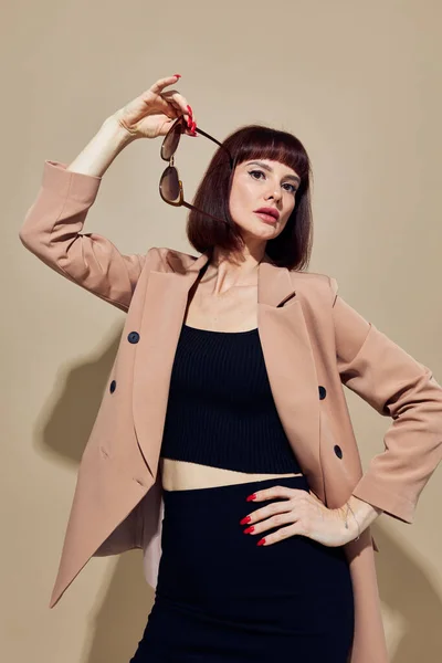 ベージュのジャケットのエレガントなスタイルのサングラスライフスタイルの女性の肖像画変更なし — ストック写真