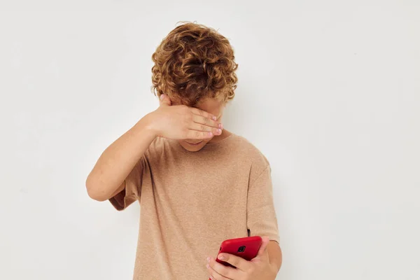 Boy beige t-shirts with phone posing technology — Stock Photo, Image