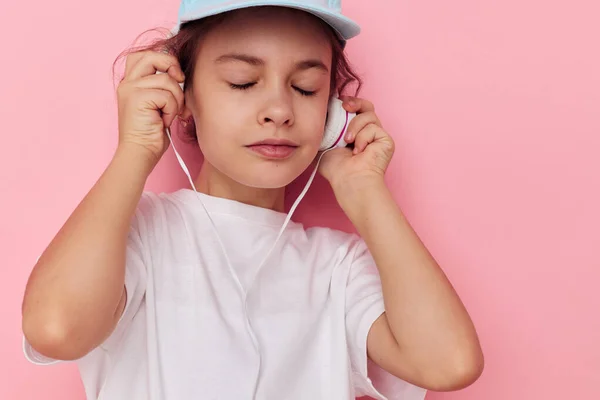 Πορτρέτο του χαρούμενου χαμογελαστού κοριτσιού φορώντας ακουστικά που θέτουν τα συναισθήματα της παιδικής ηλικίας αμετάβλητη — Φωτογραφία Αρχείου