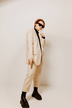 Koyu gözlüklü güzel bir kadın şık takım elbiseli moda stüdyosu değiştirilmemiş arka planlar