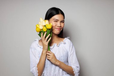Çekici Asyalı genç kadın romantizm buketi. Stüdyo modelinin yanında değişmeden duruyor.