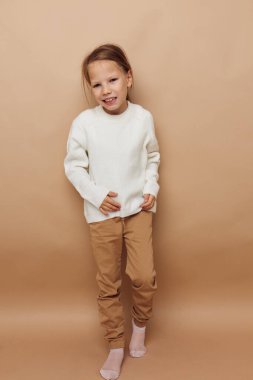 Beyaz süveter giyen güzel genç kız el hareketleriyle çocukluğu değiştiriyor.