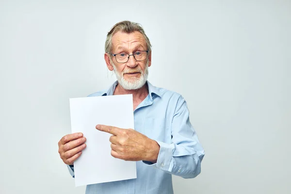 Портрет счастливого пожилого человека, держащего лист бумажного копировального пространства на изолированном фоне — стоковое фото