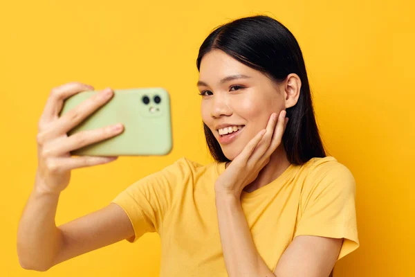 휴대 전화를 손에 들고 있는 아시아인의 아름다운 모습은 아무런 변화 없이 셀카 생활 양식을 만들어 낸다 — 스톡 사진
